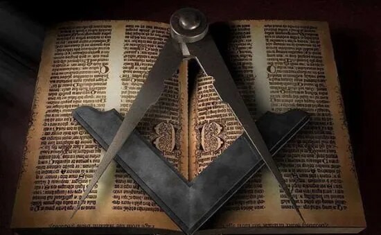 Escuadra y compás de metal sobre las páginas de un libro antiguo