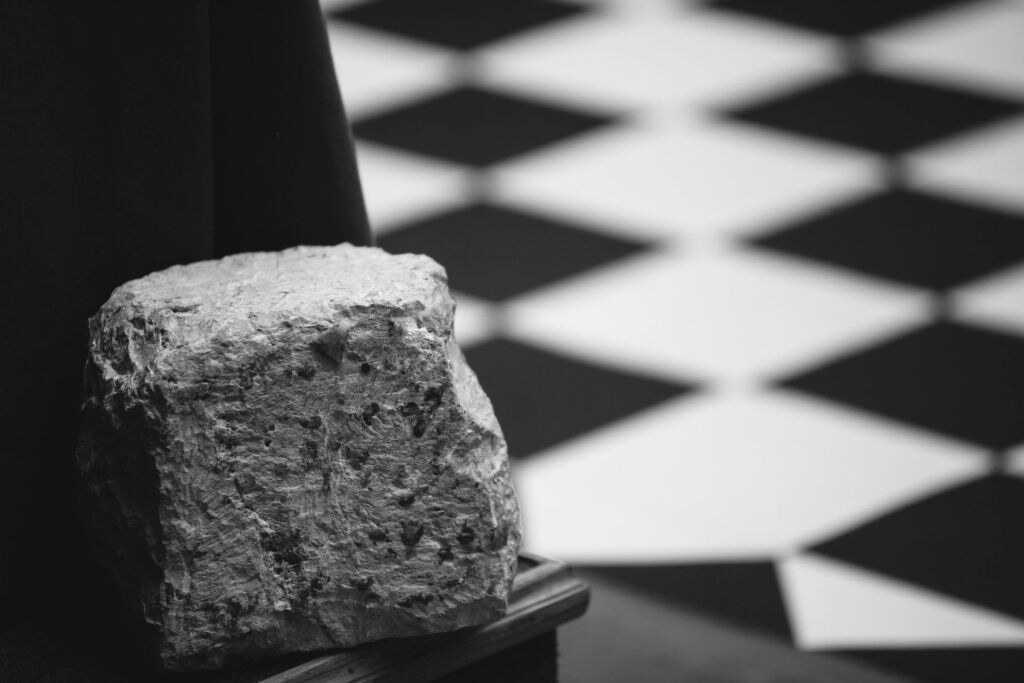 Piedra bruta sobre un pavimento ajedrezado